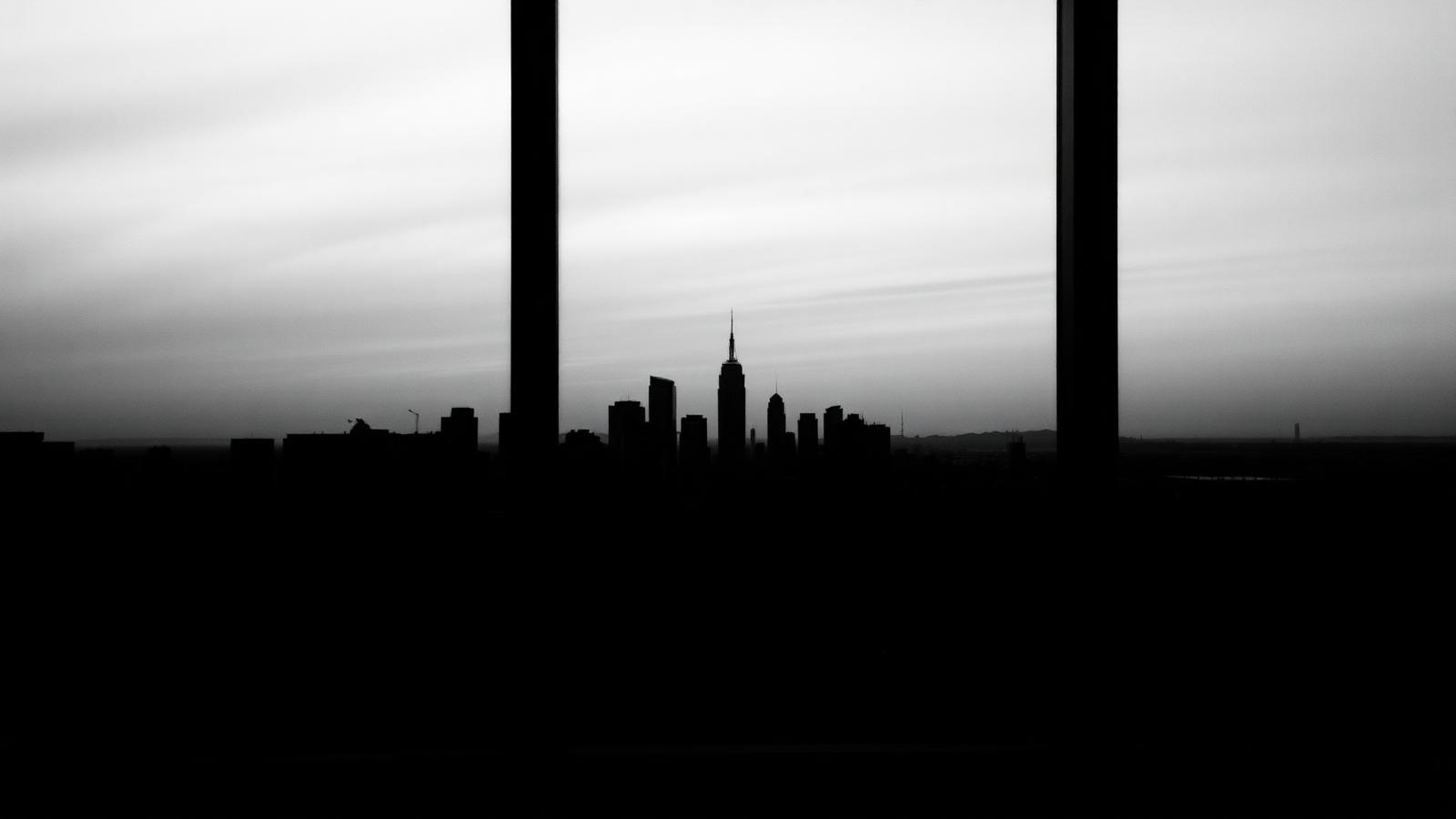 Zwart-wit zicht door een raam op een skyline